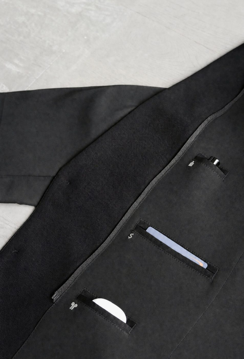 Interior pockets holding a card and earbuds, each opening marked with an icon