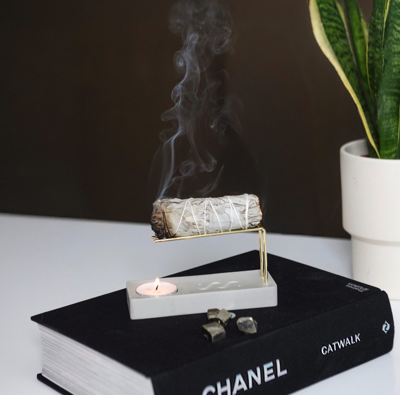 The sage burner with tealight, styled on a black art book