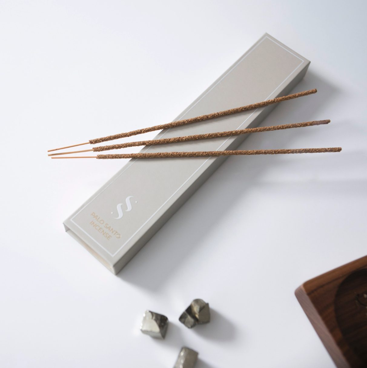 Palo Santo incense in its printed box with loose sticks and pyrite